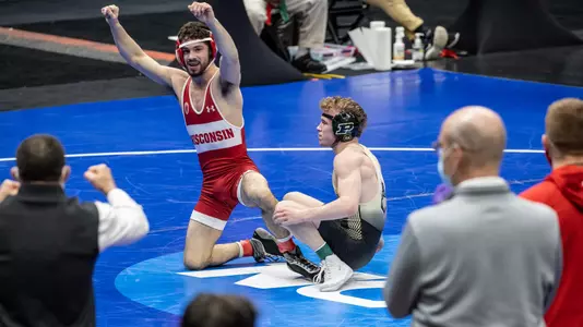 Wisconsin wrestler Eric Barnett celebrates a 5-4 decison win over Purdue's Devin Schroder at the 2021 NCAA Championships in St. Louis. The win earned Barnett his first All-America Honor. He's looking at Wisconsin coaches Chris Bono and Seth Gross.