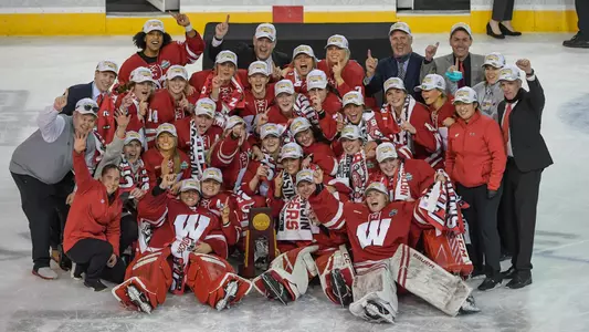 Women's hockey holding the NCAA National Championship trophy