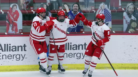 Cole Caufield celebrates with Ty Pelton-Byce and Linus Weissbach