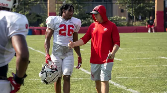 Wisconsin football defensive coordinator Jim Leonhard coaches safety Travian Blaylock (26) at fall camp August 2021