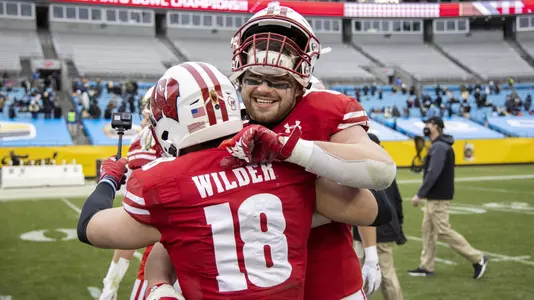 Wisconsin Badgers teammates Jake Ferguson (84) and Collin Wilder (18) celebrate a victory after an NCAA college football game at the Duke’s Mayo Bowl against the Wake Forest Demon Deacons Wednesday, Dec. 30, 2020, in Charlotte, NC. The Badgers won 42-28. (Photo by David Stluka/Wisconsin Athletic Communications)