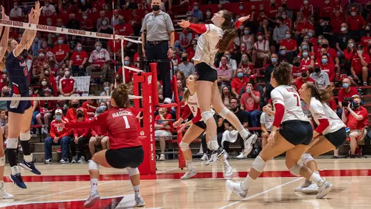 Dana Rettke attacks the ball against two Dayton blockers.