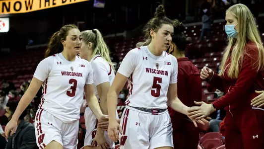 Julie Pospisilova and Brooke Schramek slaps hands with bench players.