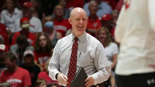 Kelly Sheffield smiles on the bench during a match.