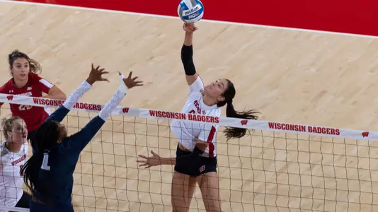 Caroline Crawford goes up for a kill against two PSU blockers.