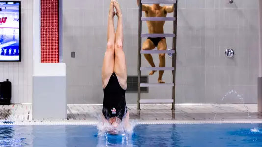 A women's diver entering the water.