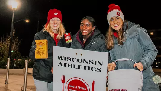 Student-Athletes holding non-perishable items for the Thanksgiving Basket Drive
