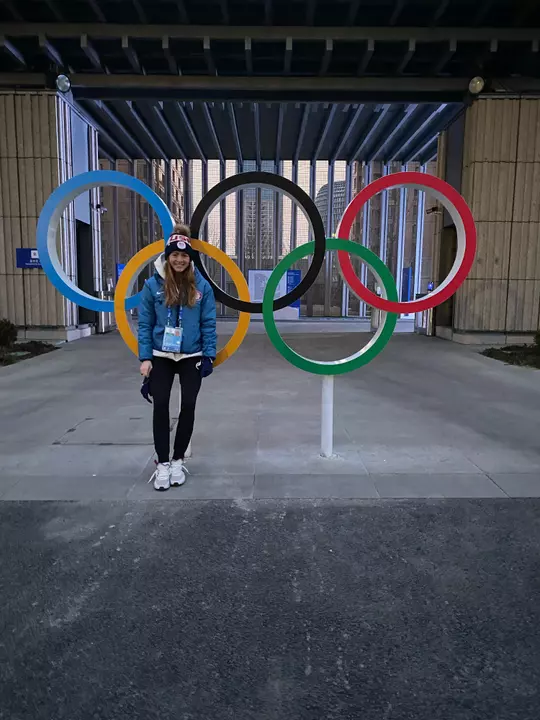 Jesse Compher, Wisconsin Women's Hockey, stands in front of Olympic Rings in Beijing, China