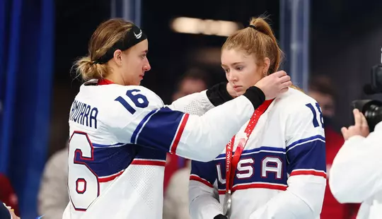 BEIJING, CHINA - FEBRUARY 17: Hayley Scamurra #16 gives teammate Jesse Compher #18 of Team United States a silver medal after the Women's Ice Hockey Gold Medal match between Team Canada and Team United States on Day 13 of the Beijing 2022 Winter Olympic Games at Wukesong Sports Centre on February 17, 2022 in Beijing, China. (Photo by Elsa/Getty Images)