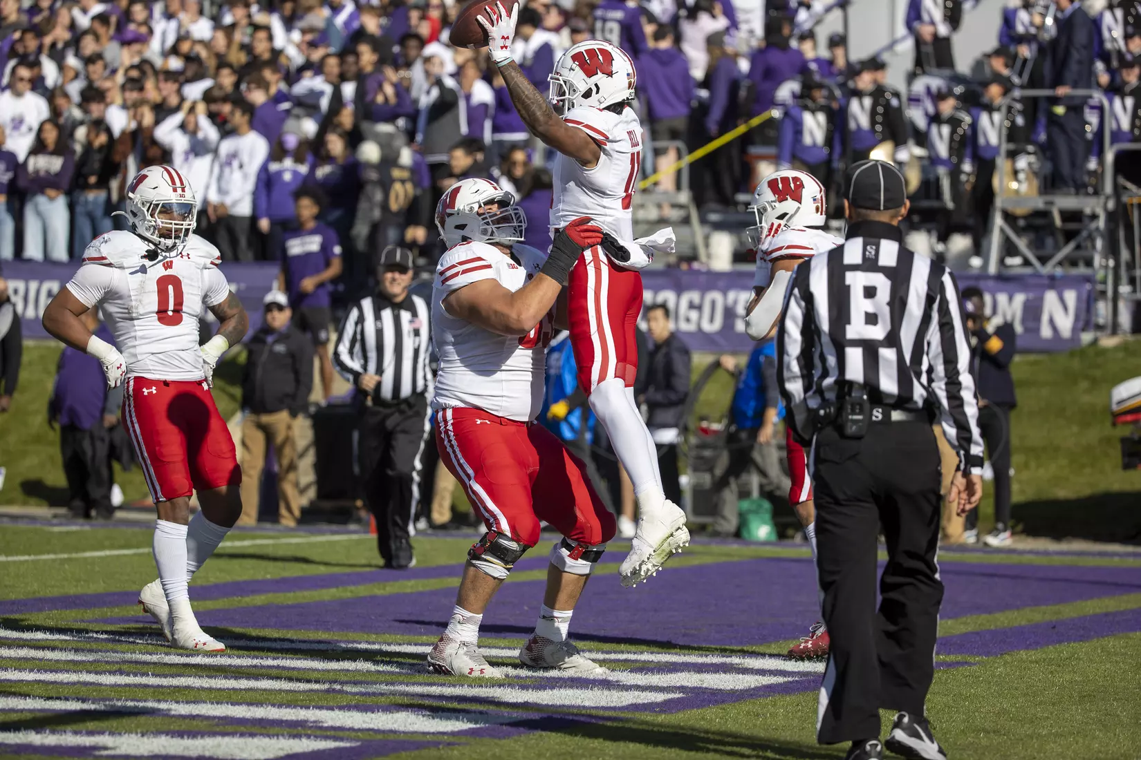 Wisconsin Badgers teammates lift wide receiver Skyler Bell (11) after he scored a touchdown during an NCAA Big Ten Conference college football game against the Northwestern Wildcats on Saturday, Oct. 8, 2022, in Evanston, Ill. The Badgers defeated the Wildcats, 42-7.