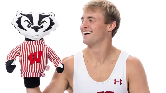 Gavin Model, Wisconsin wrestling, smiles at a Bucky Badger puppet on his right hand