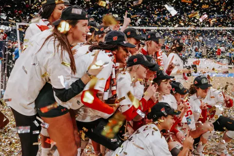 Wisconsin volleyball team photo with gold confetti falling after Badgers win the 2021 NCAA Championship