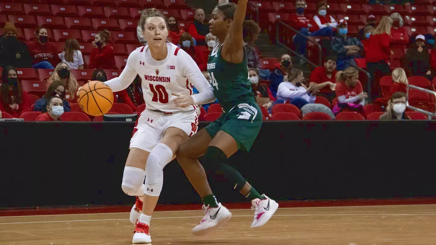 Halle Douglass dribbles around a Michigan State defender.