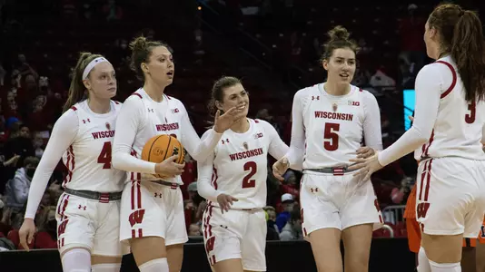 The Badgers celebrate their victory over Illinois on the court.