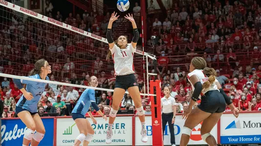 Izzy Ashburn sets up the ball while Devyn Robinson waits to hit.
