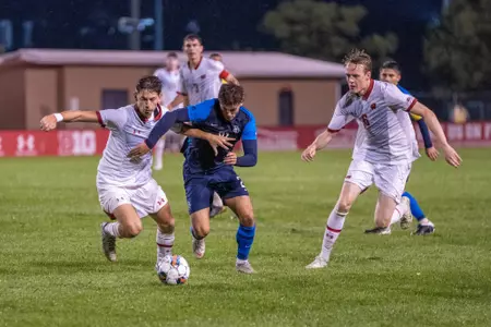 Wisconsin's Michael Wampler and Aron Saevarsson attempt to win the ball back from a Marquette player at McClimon on Monday