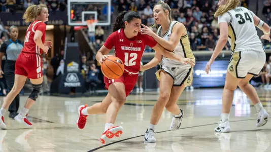 Avery LaBarbera dribbling through the lane with a Purdue defender nearby