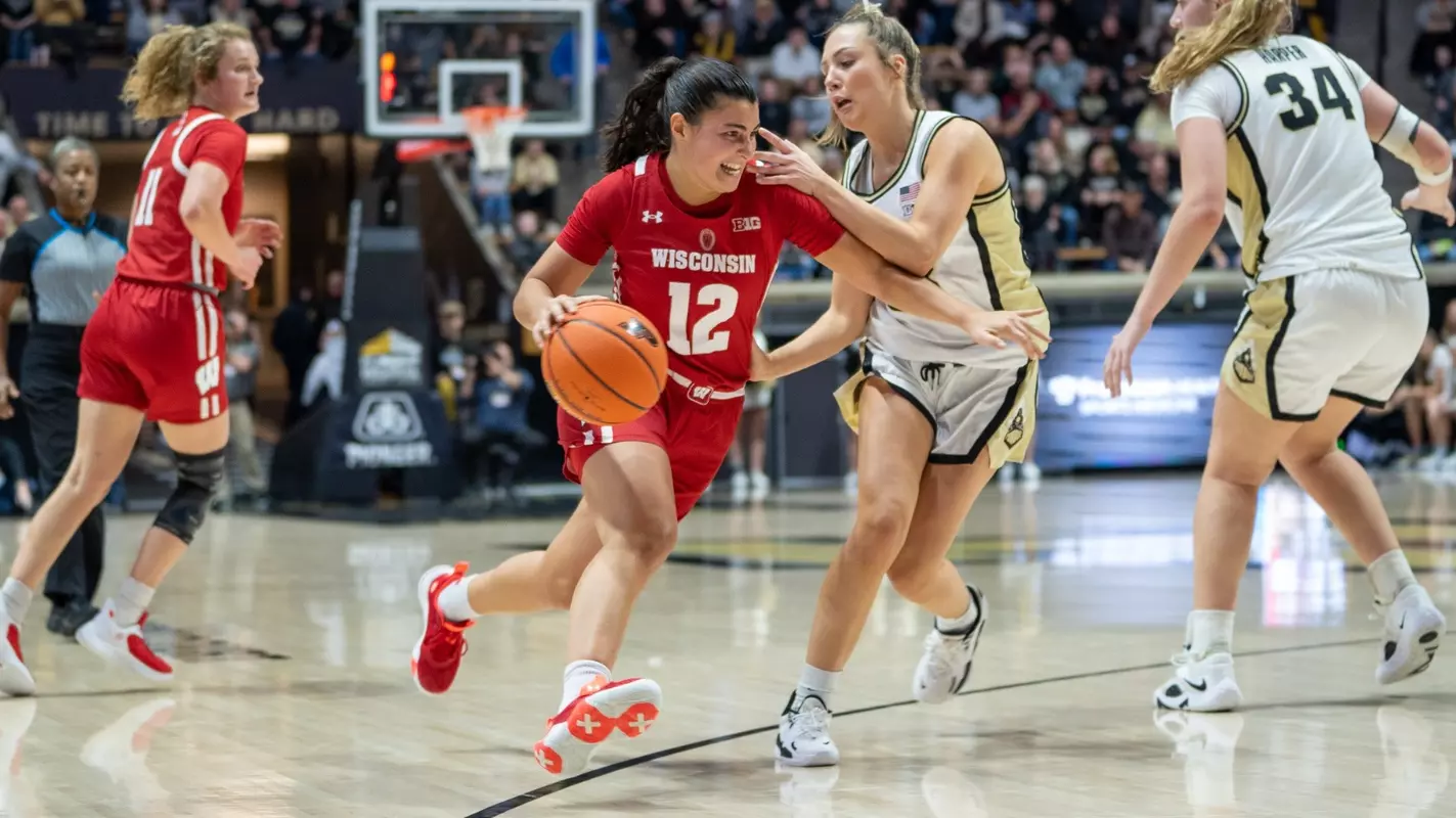 Avery LaBarbera dribbling through the lane with a Purdue defender nearby