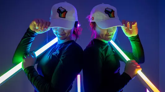 Mary Ferrito and Lily Krahn posing with Wisconsin Pride hats