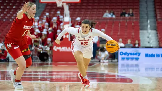 Avery LaBarbera dribbling through the lane next to a Maryland defender