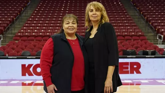 Janet and Theresa Huff posing at the center of the Kohl Center floor