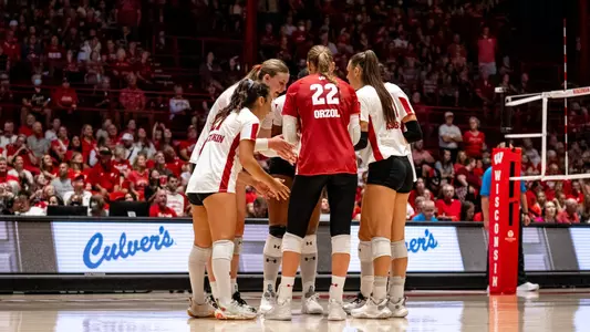 The starting lineup huddles before the start of the match vs Michigan