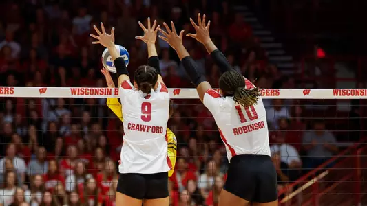 CC Crawford and Devyn Robinson block the ball in match against Michigan