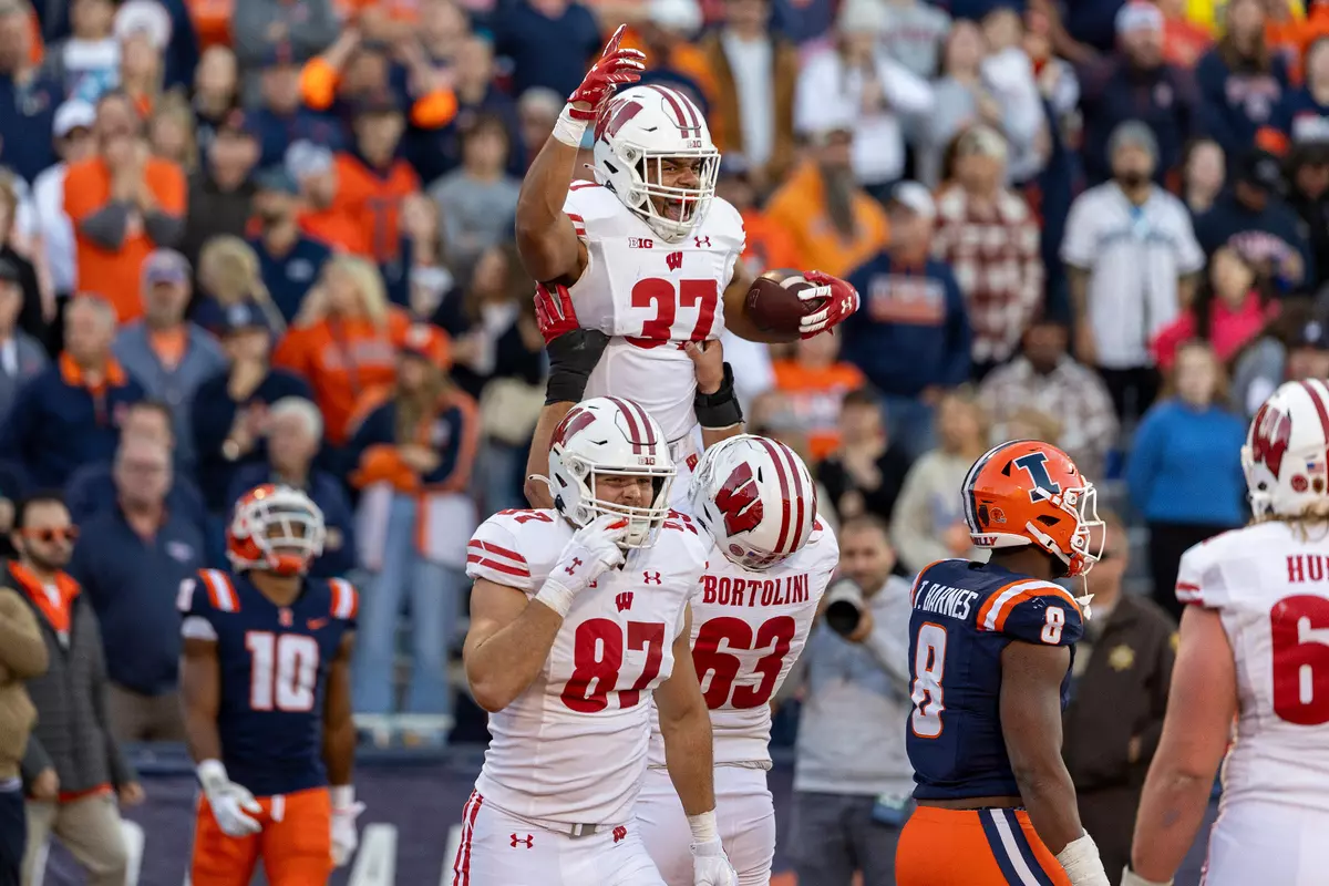Wisconsin football tight end Riley Nowakowski (37) is lifted up by his teammates in celebration during the Badgers 25-21 comeback victory at Illinois on Saturday, Oct. 21, 2023 in Champaign, Ill.