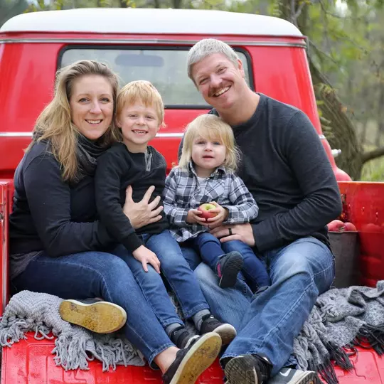 Sharon (Cole) Faust, Wisconsin women's hockey alumnus, with her husband Jesse and their two children