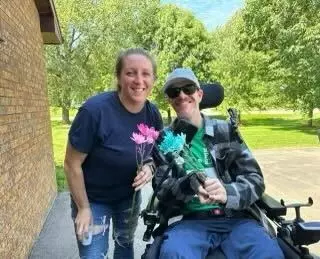 Sharon (Cole) Faust, Wisconsin women's hockey alumnus, with her husband Jesse in his wheelchair