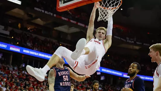 Tyler Wahl hangs on the rim after a dunk vs. Robert Morris