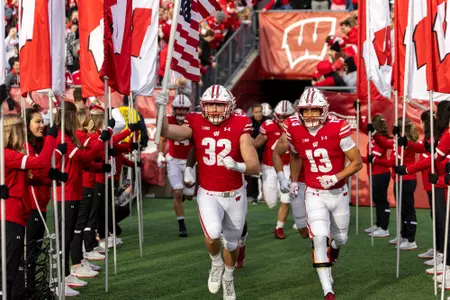 Wisconsin Badgers captains Marty Strey (32) and Chimere Dike (13) lead the team out during a Big Ten Conference NCAA college football game against the Northwestern Wildcats, Saturday, Nov. 11, 2023, in Madison, Wis. The Wildcats won 24-10. (Photo by David Stluka/Wisconsin Athletic Communications)