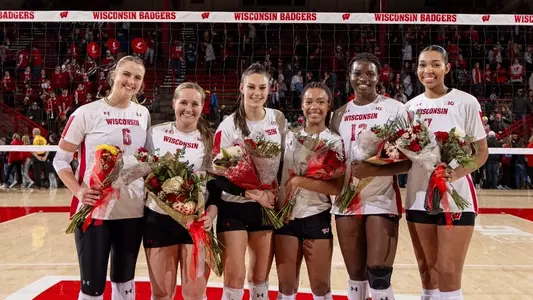 Seniors pose in front of net on Senior Night