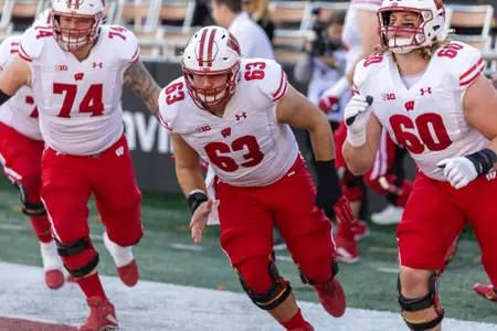 Wisconsin football offensive linemen Michael Furtney (74), Tanor Bortolini (63) and Joe Huber (60) warm-up prior to Wisconsin's NCAA Football game at Indiana on Saturday, Nov. 4, 2023.