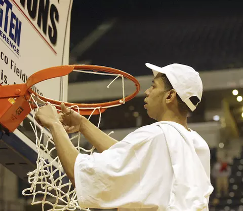 Indianapolis, IN - 3/14/04.  University of Wisconsin Devin Harris cuts down a piece of the net after defeating Illinois in the title game at Conseco Fieldhouse. Wisconsin beat Illinois 70-53. ©David Stluka