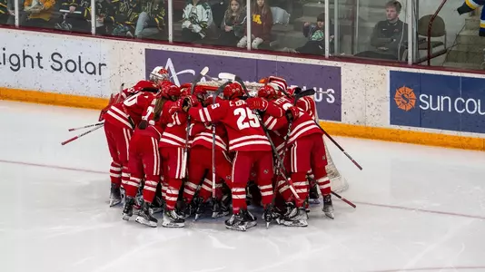Wisconsin women's hockey huddles around the net before a game against Minnesota on Dec. 8, 2023