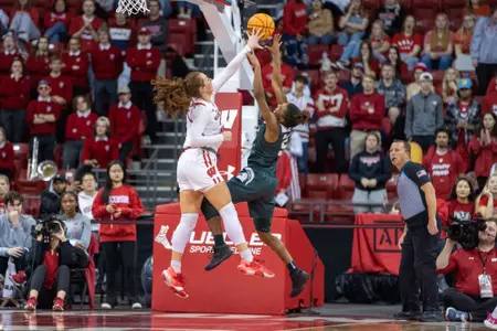 Brooke Schramek blocks Michigan State player layup attempt.