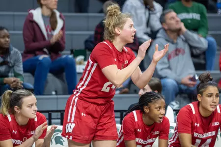 Natalie Leuzinger cheers and claps her hands from the bench.