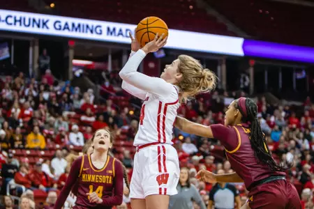 Natalie Leuzinger attempts to shoot a layup against Minnesota defenders.