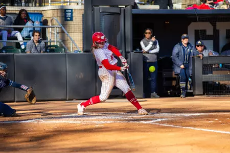 Wisconsin softball player hitting the ball