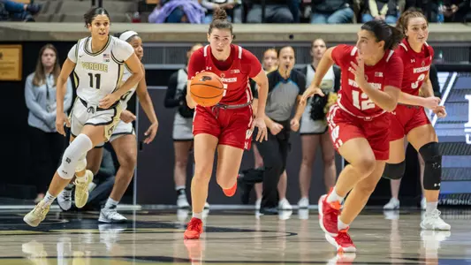 Julie Pospisilova dribbling down the court on a fastbreak with Avery LaBarbera running along