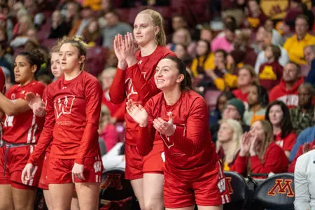 Mary Ferrito and Sacia Vanderpool clapping and cheering from the bench.