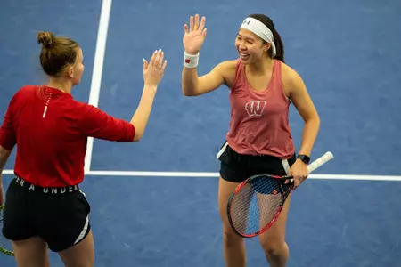 Charmaine Seah and Alina Mukhortova high-five during a match