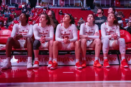 The starters watch the video board from the bench.