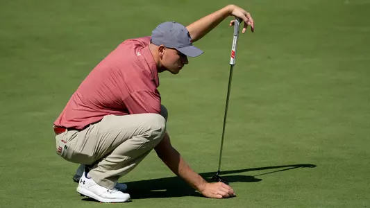 Daniel Aas, men's golf, lines up the ball for a putt at the 2022 Badger Invitational at University Ridge Golf Course