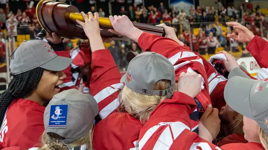 Women's Hockey Players hold up the NCAA trophy following their 1-0 win over Ohio State