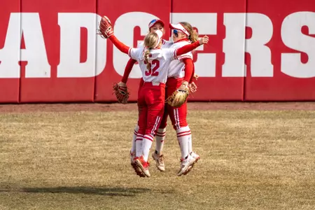 Badger outfielders chest bumping in the field
