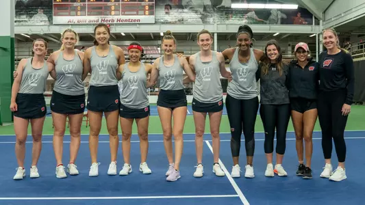 The women's tennis team posing before the start of a match