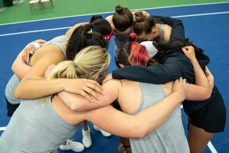 The Wisconsin women's tennis team in a huddle