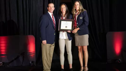 AJ Whitehead receiving her Master Strength and Conditioning Coach award on stage